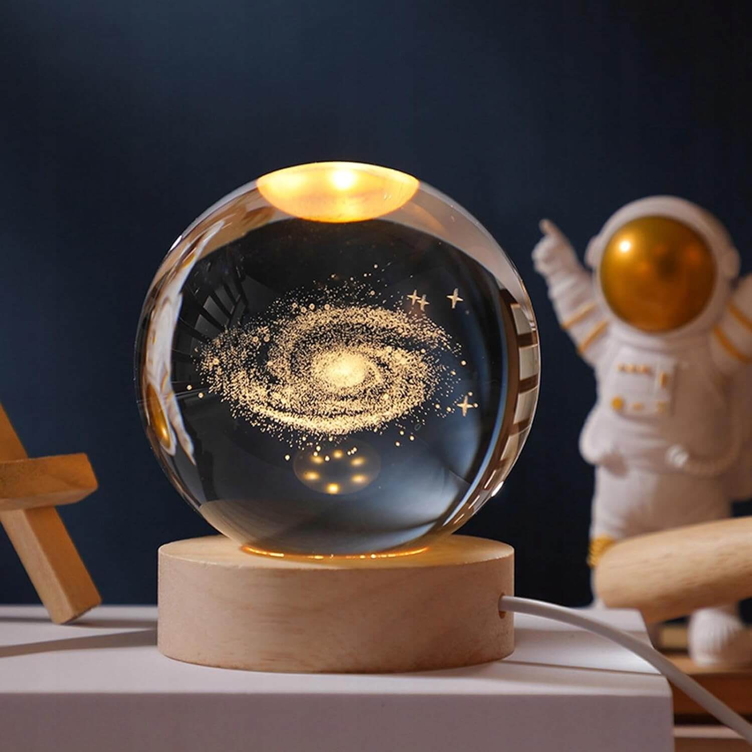 Illuminated Galaxy Crystal Ball with swirling galaxy design on wooden base, perfect for space enthusiasts and home decor.