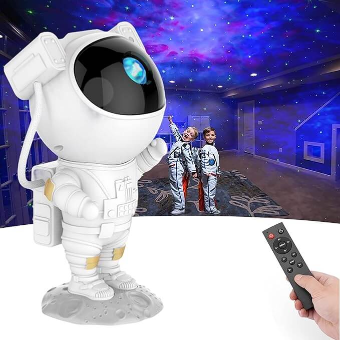 Astronaut galaxy projector creates celestial lighting in a room, highlighting two children dressed as astronauts and a hand holding a remote control.