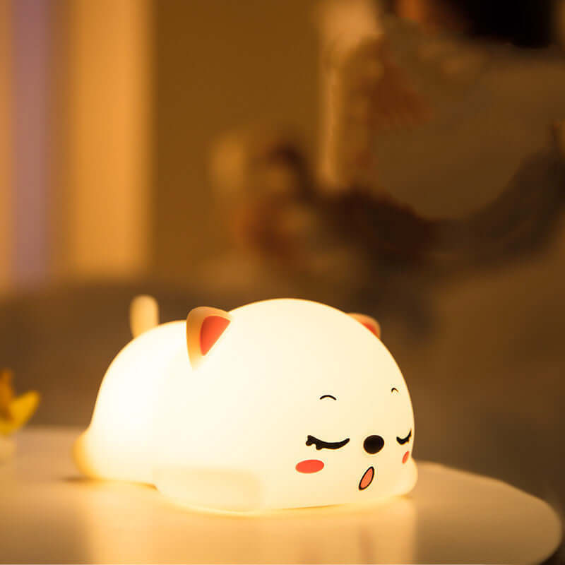 Adorable squishy cat lamp glowing softly on a table, perfect for cozy nights.